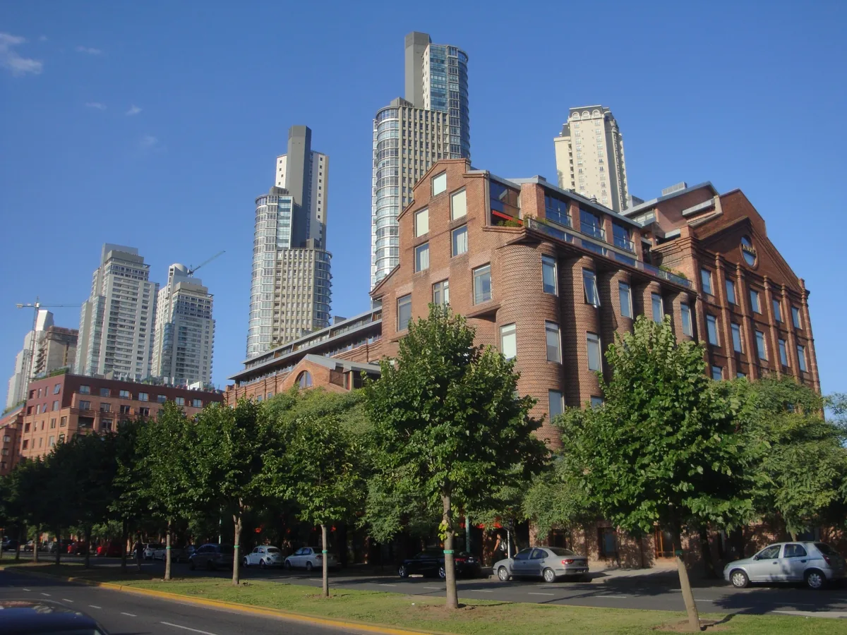 Daytime exterior view of the Faena Hotel and Universe complex in Puerto Madero, Buenos Aires — the converted red-brick grain mill building against the Puerto Madero skyline